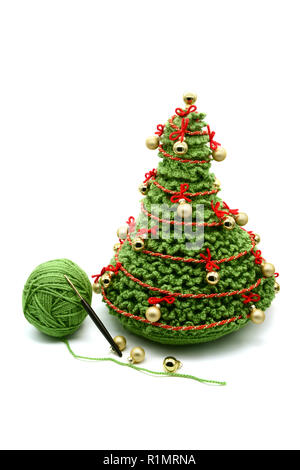 Albero di natale con palline dorate crochet di lana bianca di sfondo isolato. Lana palla e uncinetti da parte. Foto Stock