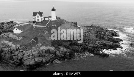 Il rosso faro di luce Nubble avverte i naviganti di rocce pericolose e navigare sull'Oceano Atlantico Costa Orientale Foto Stock