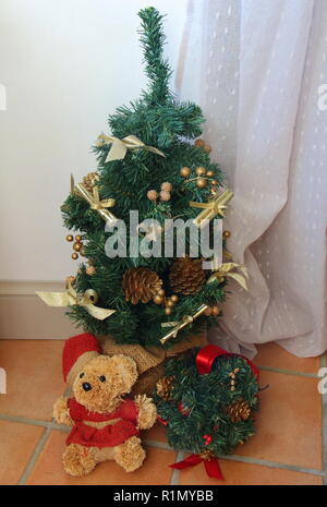 Piccolo albero di Natale artificiale e babbo natale orsacchiotto Foto Stock