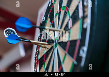 Freccia Dart di colpire nel target center di dartboard Foto Stock