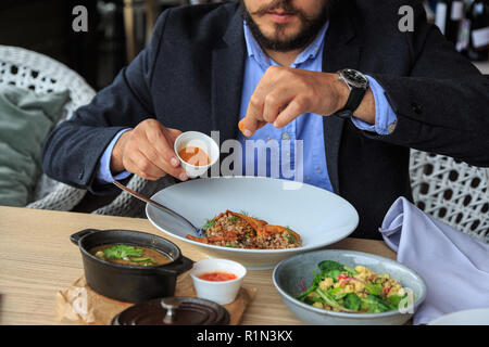 L uomo è di mangiare in un ristorante e gustare deliziosi cibi Foto Stock