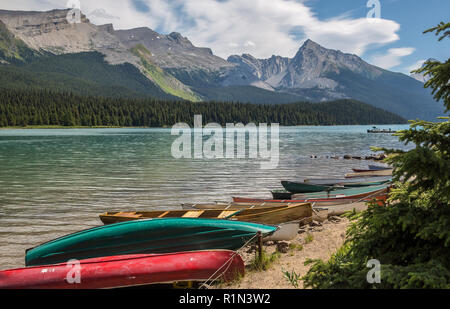 Canoe e altre imbarcazioni lungo la riva del Lago Maligne nel Parco Nazionale di Jasper, Alberta Canada Foto Stock