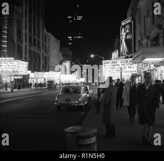 Degli anni Cinquanta, storico, Manhattan, New York City e una vista di Times Square in serata che mostra il cinema con alcune delle più grandi stelle del cinema dell'epoca. Foto Stock