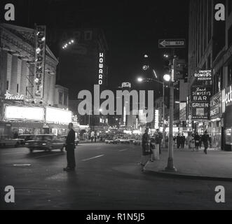 Degli anni Cinquanta, la serata in Broadway,mid-town Manhattan, New York City, Stati Uniti d'America e le luci al neon di cinema, teatri e bar illumina la strada. Il bar e il ristorante del famoso pugile americano, jack Dempsey può essere visto, come può la Howard Hotel e il gran teatro Rivoli che mostra il film, il suono della musica, che si è aperto il 3 marzo e ha funzionato per 93 settimane. Purtroppo questo sontuoso edificio inaugurato nel 1917 con un film interpretato da Douglas Fairbanks è stata abbattuta nel 1987 e sostituita da un vetro nero grattacielo, il destino di molti un bel vecchio edificio nella città di New York. Foto Stock