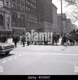 Degli anni Cinquanta, i newyorkesi in attesa di attraversare la strada all'intersezione st West 42nd Street, Manhattan, New York New York City, Stati Uniti d'America. Un importante attraversate street, la zona è famosa per la sua theates e Broadway. Famoso American retail nomi come saggio di scarpe, fondata nel 1938, e Rogers Peet, un abbigliamento uomo azienda fondata nel 1874, può essere visto nella foto a sinistra. Foto Stock