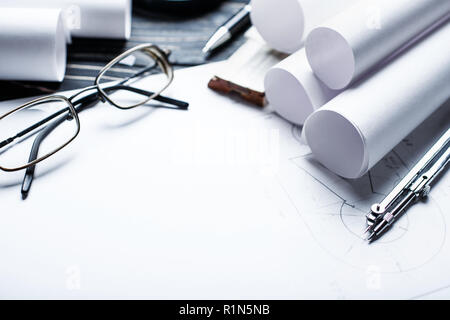 Sul tavolo di legno vi sono disegni, bussole, matita, righello e bicchieri. Foto Stock