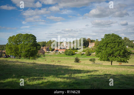 Una vista del villaggio di Ewelme, Oxfordshire con la sua scuola di villaggio e gli ospizi di carità bagnata nel pomeriggio di sole estivo. Foto Stock