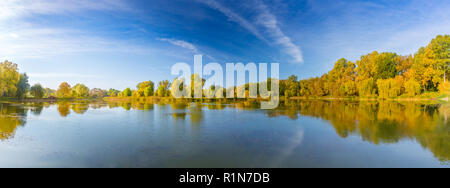 Laguna specchio arrotondati da montagne, autunno magnifico lago di riflessione e colorati di foglie di albero Foto Stock