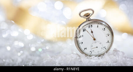 Il veglione di Capodanno il conto alla rovescia. Minuti a mezzanotte su un vecchio orologio da tasca, bokeh sfondo, spazio di copia Foto Stock
