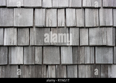 Le scandole di legno schierandosi a parete in larice. Vecchio, decolorata e indossato da tempo le assicelle. Tradizionale casa austriaca schierata. Foto Stock