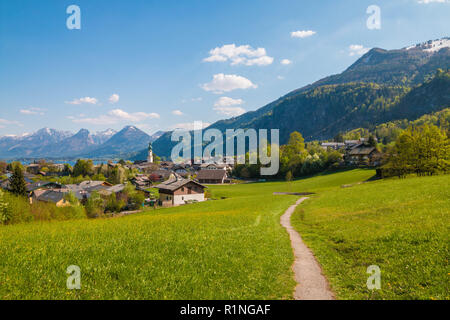 Splendida vista delle Alpi città austriaca St.Gilgen sul lago Wolfgangsee, percorso a piedi attraverso un prato verde e le montagne sullo sfondo. Salzburger Foto Stock