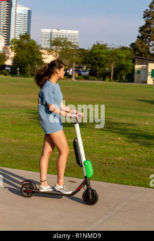 Donna su un 'calce " scooter elettrici a cavallo su un sentiero a San Diego, California, Stati Uniti. Foto Stock