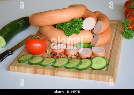 Lyoner è una salsiccia delicatessen su un rustico in legno piastra. Lyoner ist eine Wurstspezialität auf einer rustikalen Holzplatte. Foto Stock
