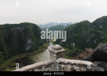 Ninh Binh, Vietnam. Foto di calcare montagne, colline con vegetazione verde e il fiume che scorre tra di essi. Anche visto, stormo di uccelli bianco può essere Foto Stock