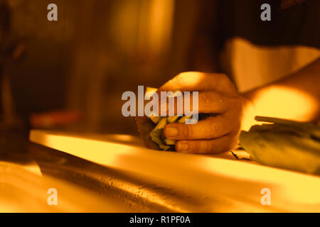 Le mani con il taglio di vegetali in cucina di mattina Foto Stock