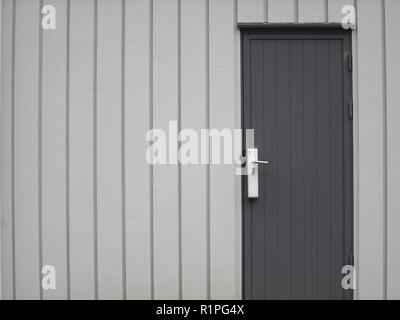 Linguetta e scanalatura di legno muro grigio e porta. Foto Stock