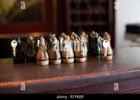 Tasti hotel. Tasti giacente sul contatore di hotel. Tasti di colore marrone con un portachiavi in legno giacente sul contatore dell'hotel e l'attesa per gli ospiti. Foto Stock