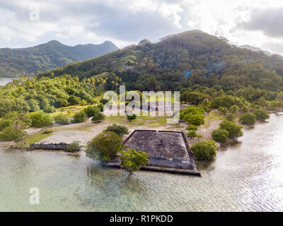Antico Marae Taputapuatea tempio complesso sulla laguna a riva con le montagne sullo sfondo. Isola di Raiatea. Sottovento, Isole della Società, Polinesia Francese Foto Stock