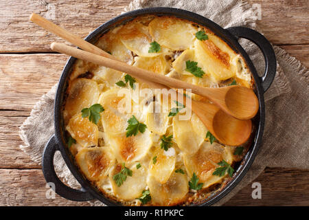 Cucina finlandese Janssonin Kiusaus. Patate al forno con le acciughe, cipolle e crema di latte in una padella. Parte superiore orizzontale vista da sopra Foto Stock