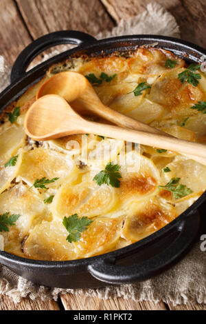 Cucina finlandese Janssonin Kiusaus. Patate al forno con le acciughe, cipolle e crema di latte in una padella sulla tavola verticale. Foto Stock