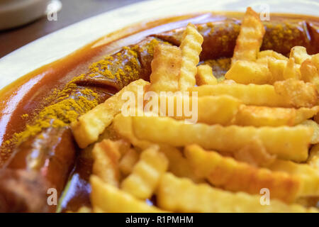 Currywurst (curry wurst, Tedesco salsiccia) e patatine fritte close up food fotografia. Germania piatto, cucina tedesca, paprica, piccante. Foto Stock