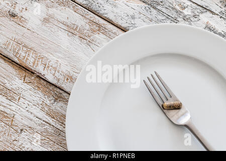 Compresse con forca d'argento su un vecchio tavolo in legno Foto Stock