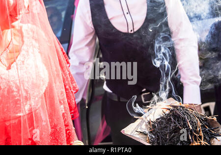 La tradizione sciamanica per buona fortuna nelle zone rurali la Turchia. Incenso di bastoncini di erbe fuma va a coppie giovani in una cerimonia di matrimonio. Foto Stock