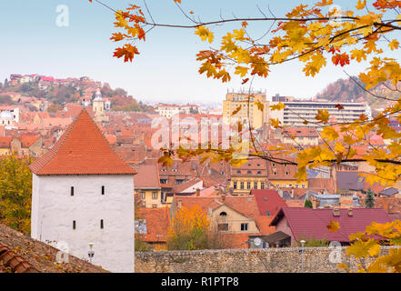Tetti in mattoni della città di Brasov, visto da un punto più alto, vicino alle pareti di guardia della ex fortezza. Bella giornata autunnale Foto Stock