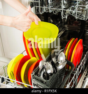 Houswork concetto aperto con lavastoviglie e mani femminili che mostra con il pollice in alto Foto Stock