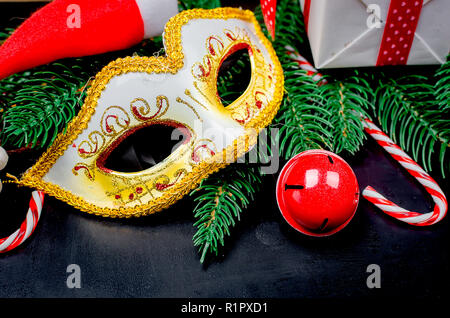 White maschera di carnevale e le decorazioni di Natale su sfondo nero/ vacanze concetto, spazio di copia Foto Stock