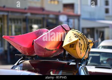 In plastica colorata kayak strapped sulla parte superiore del tetto del veicolo. Foto Stock