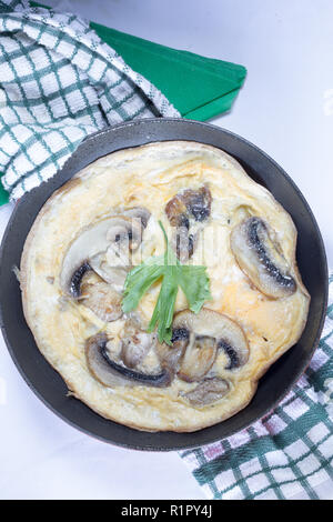 Una frittata con la cottura in un poco profondo la padella/padella Foto Stock