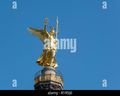 La statua dorata di Victoria sulla parte superiore della colonna della vittoria di Berlino in Germania contro un cielo blu Foto Stock