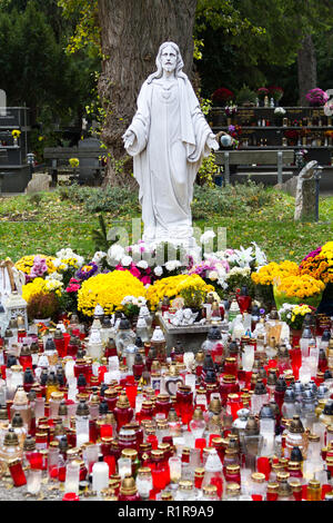 Una statua del Sacro Cuore di Gesù a Martinsky cintorin (cimitero) durante le tutte le anime ottava. Accendere le candele di fronte ad esso. Foto Stock