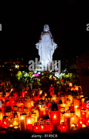 Una statua del Sacro Cuore di Gesù a Martinsky cintorin (cimitero) durante le tutte le anime ottava. Accendere le candele di fronte ad esso. Foto Stock