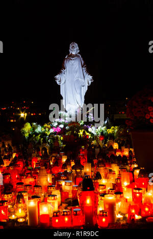 Una statua del Sacro Cuore di Gesù a Martinsky cintorin (cimitero) durante le tutte le anime ottava. Accendere le candele di fronte ad esso. Foto Stock