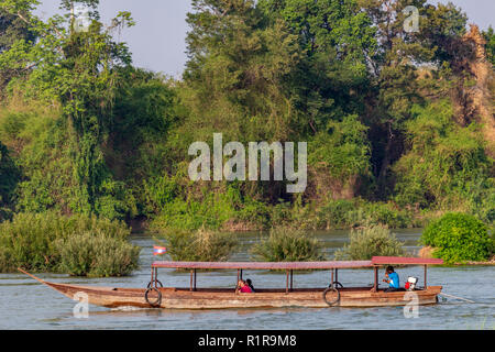 Don Det, Laos - Aprile 22, 2018: imbarcazione in legno con la navigazione del fiume Mekong circondato da foresta vicino al confine con la Cambogia Foto Stock