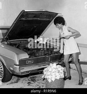 Una donna di badili denaro in riparazione auto, ca. 1971. Foto Stock