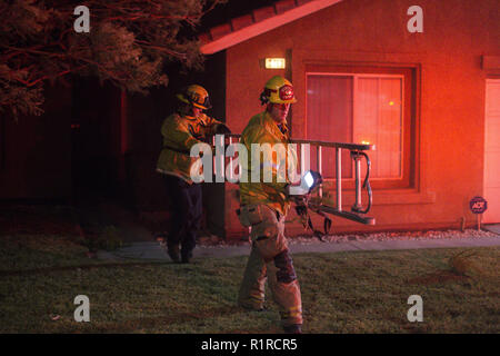 Rialto, CA, Stati Uniti d'America. Xiv Nov, 2018. Alle 9 pm, un fast-spazzola mobile incendio scoppia, bruciando 20 acri nei primi tre minuti. Rialto Fire Department pack fino, dopo aver ispezionato il tetto per i segni di fuoco. Credito: Chris Rusanowsky/ZUMA filo/Alamy Live News Foto Stock