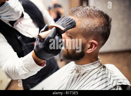 Hipster uomo client haidresser visita e un parrucchiere in un barbiere. Foto Stock