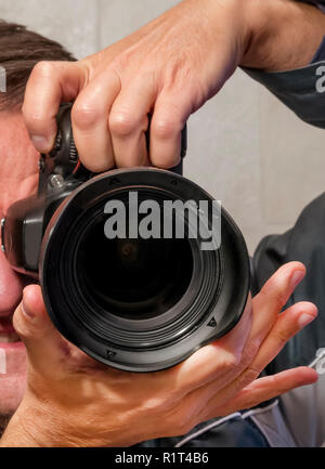 Autoritratto di mani nello specchio tenendo una fotocamera reflex Foto Stock