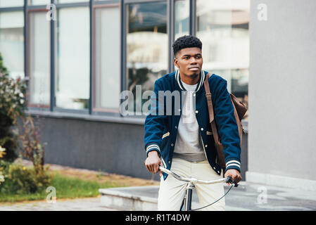 Bello African American uomo a cavallo in bicicletta in città Foto Stock