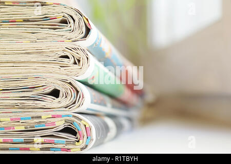 Pila di mattina freschi quotidiani sul tavolo in ufficio. Ultime notizie finanziarie ed economiche nel quotidiano. Le pagine con le informazioni in primo piano gli articoli Foto Stock