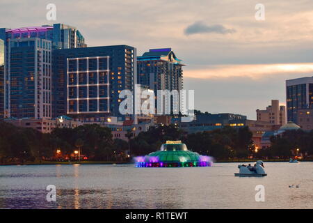 Orlando, Florida; 05 settembre 2018. Swan barche a remi a noleggio a Lake Eola Park e fontana colorata sul bellissimo tramonto Foto Stock