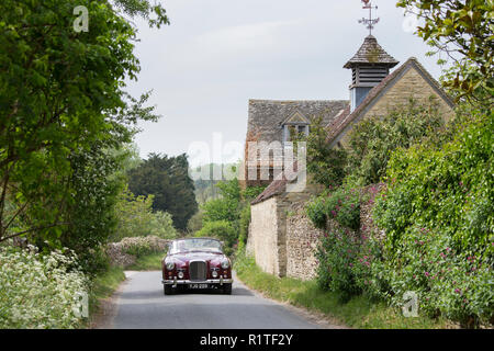 Automobilista la guida 1961 British realizzato Alvis TD21 serie DHC 1 drophead ooupe classic car in Swinbrook village, il Costwolds, Inghilterra Foto Stock