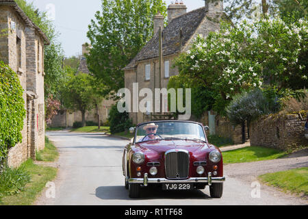 Automobilista la guida 1961 British realizzato Alvis TD21 serie 1 ooupe drophead classic car Asthall village, il Cotswolds Inghilterra Foto Stock