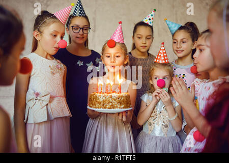 I bambini con una torta di compleanno divertirsi. Foto Stock