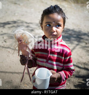 Close-up di una ragazza con una bambola e mug, Glenburn Tea Garden, Darjeeling, West Bengal, India Foto Stock