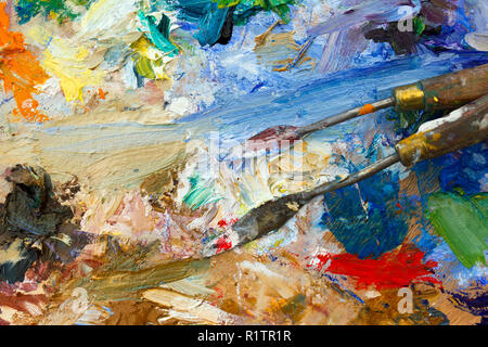La vibrante multi-colore di artisti di olio o di vernici acriliche tavolozza astratta semi close-up con i coltelli della tavolozza Foto Stock