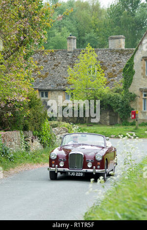 Automobilista la guida 1961 British realizzato Alvis TD21 serie DHC 1 drophead ooupe classic car sul paese lane in Cotswolds, Inghilterra Foto Stock